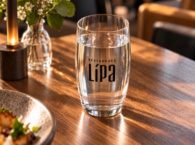 Water glass featuring a restaurant logo on a laid table
